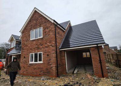 Red brick house under construction with an unfinished garage