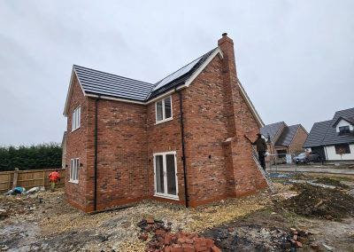 Newly built red brick house with a chimney and French doors